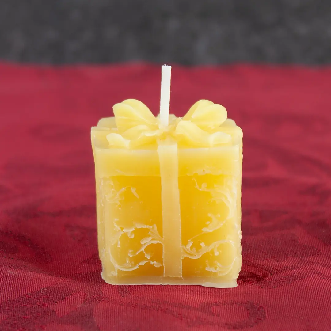 Goldgelbe Bienenwachs-Kerze in Form eines kleinen Geschenkpakets mit Schleife, 3cm Kantenlänge