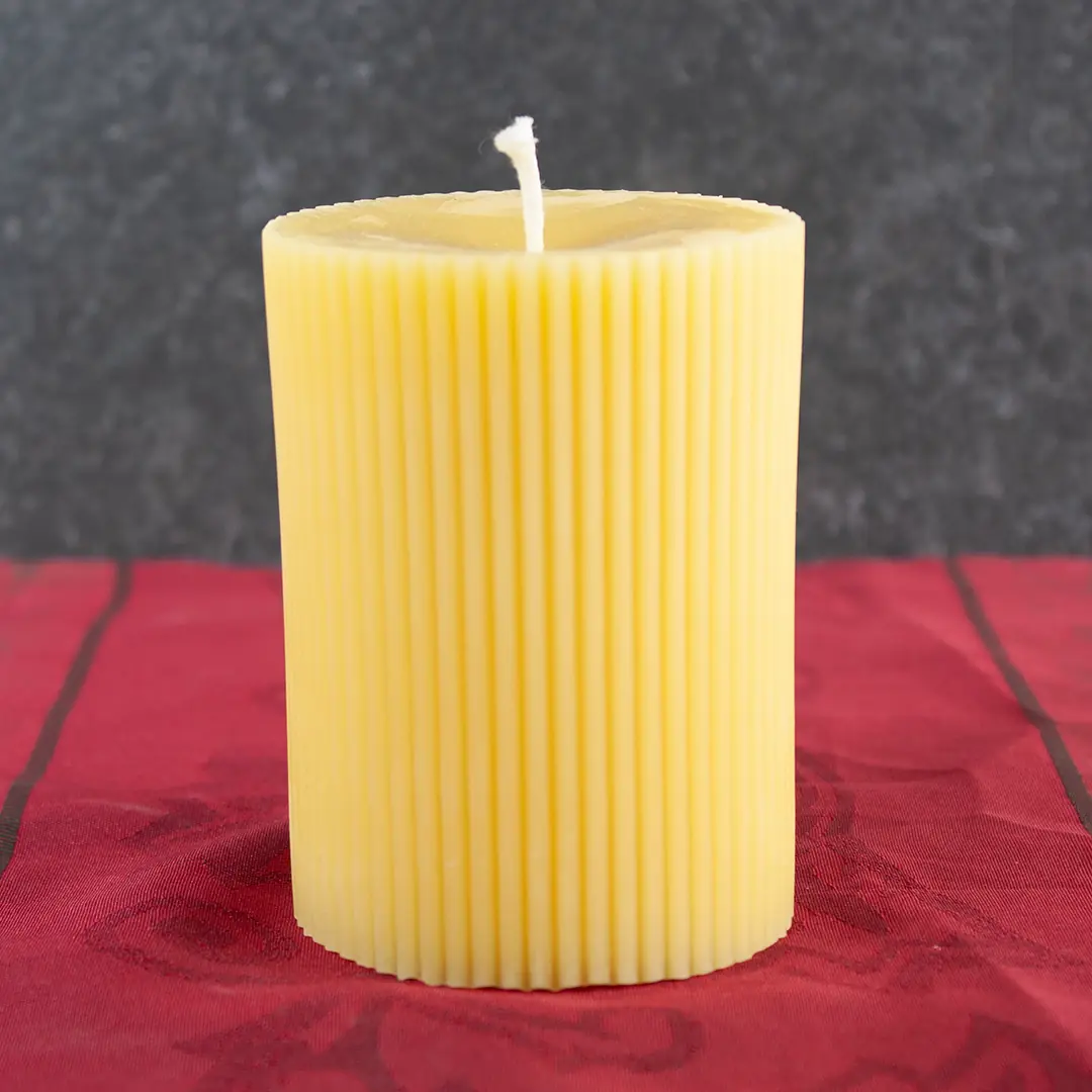 Goldgelbe Bienenwachs-Stumpfkerze mit strahlenförmigem Sternenmuster, 7cm Durchmesser und 9,5cm Höhe