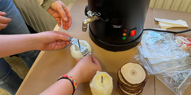 Schulkinder beim Kerzengießen mit Bienenwachs in Gebrüder-Grimm-Grundschule